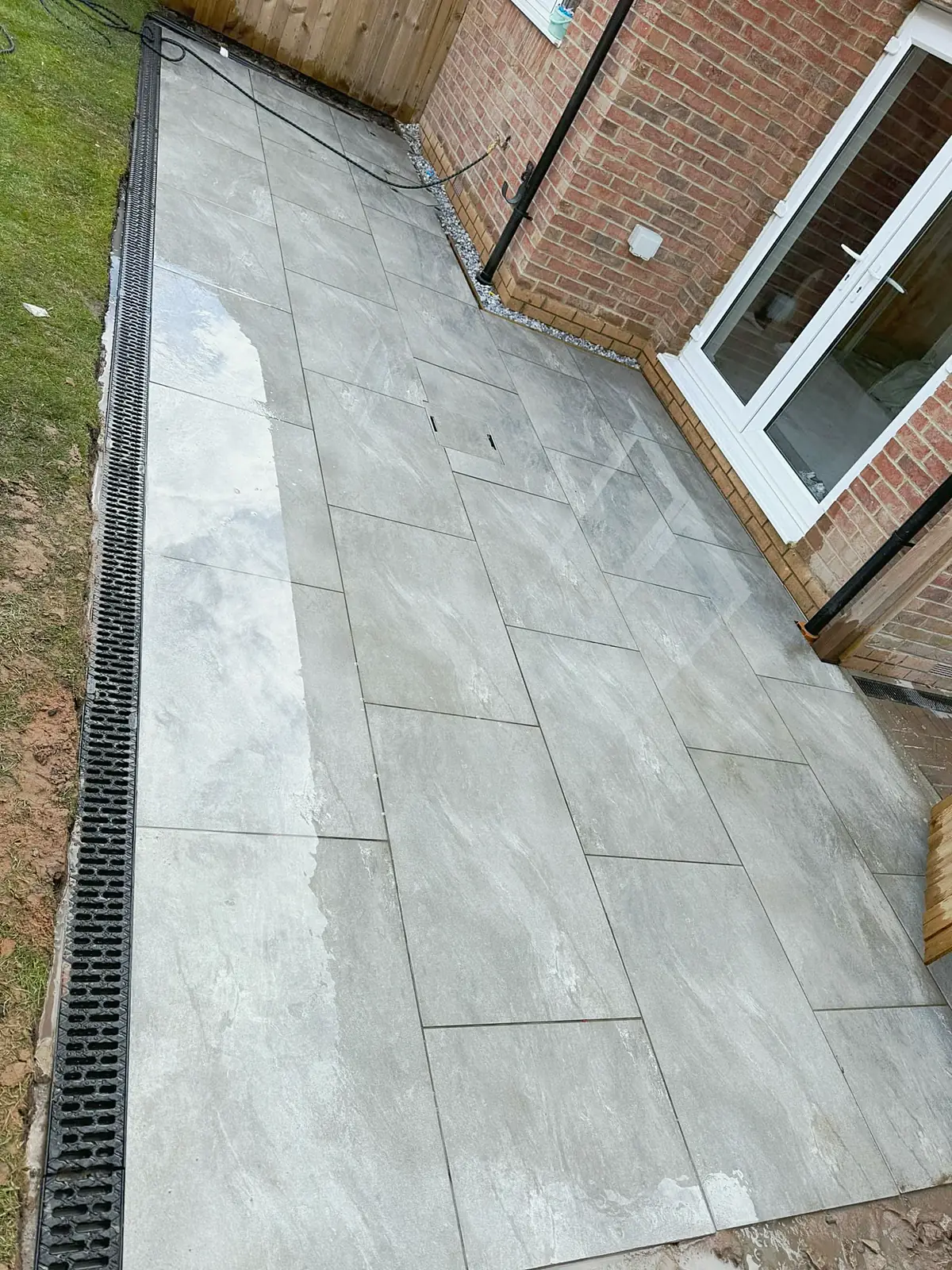 Large format porcelain patio along the side of a house