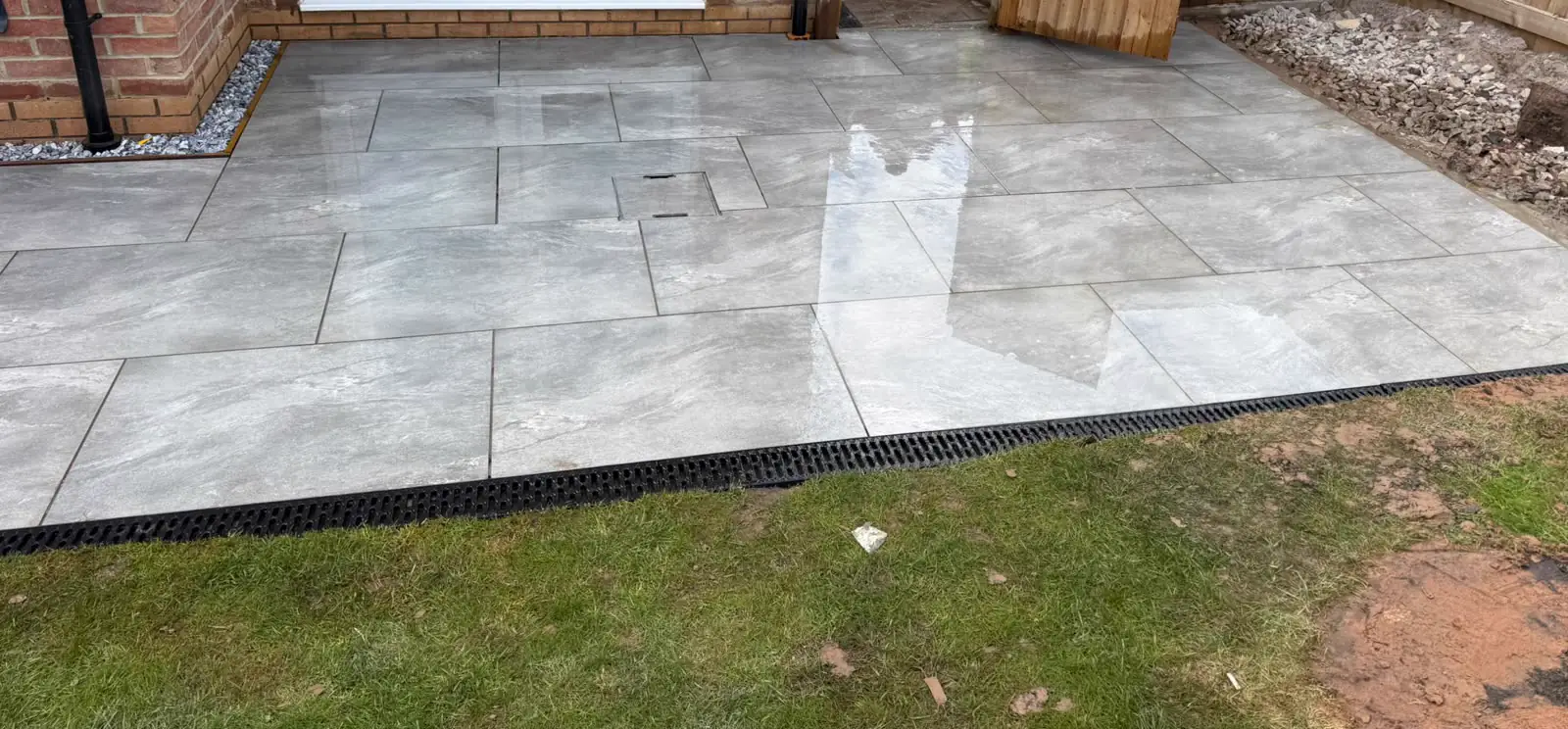 Porcelain patio outside French doors next to a timber gate