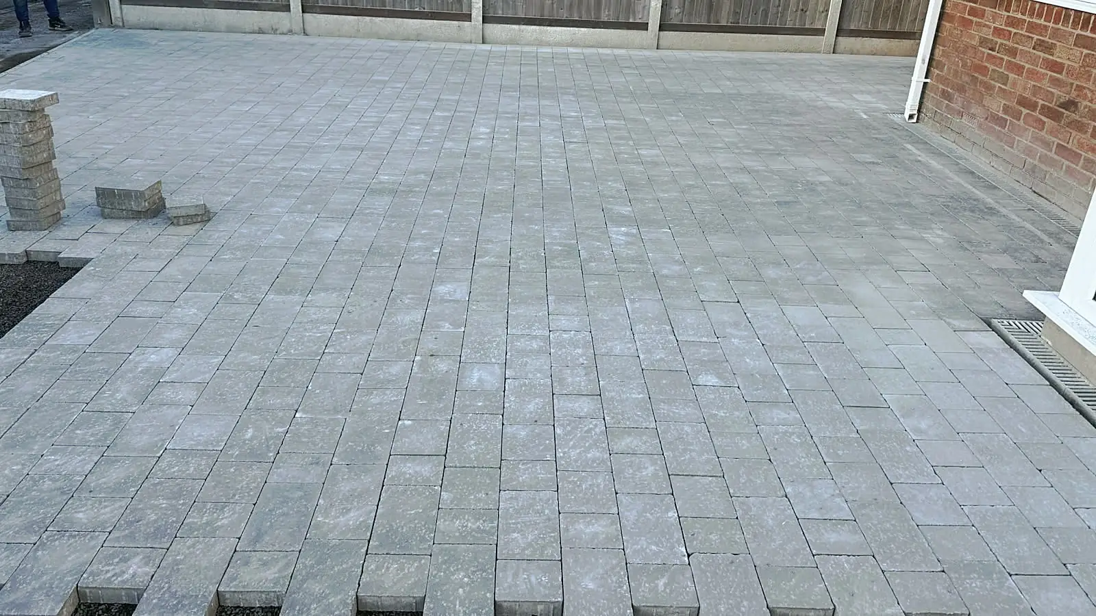 Large grey block paved area behind a house