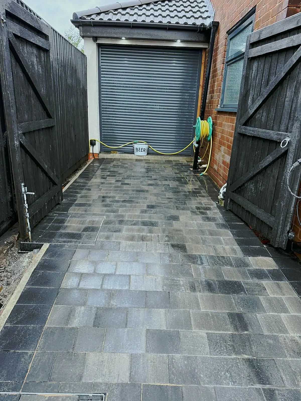 Charcoal and grey block paving leading to a garage door