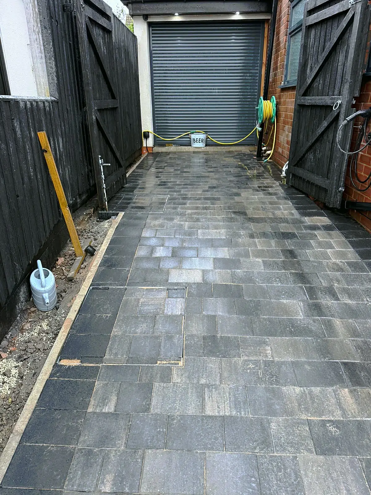 Block paved side driveway leading to a garage