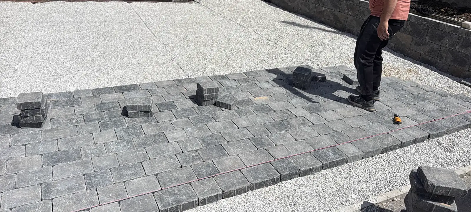 Laying block paving to a string line